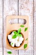 mozzarella in a wooden bowl with basil