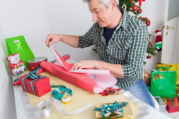 Man wrapping gifts