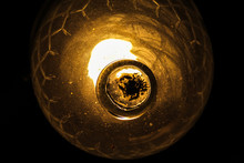 Antique Orange Glass Lamp.
There Are Dead Bugs At The Bottom Of The Lamp.
Black Background.