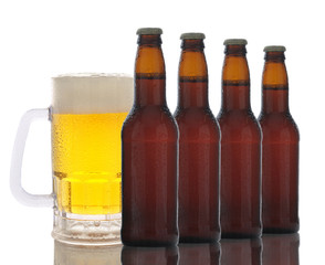 Wall Mural - A frosty mug of beer behind a row of brown beer bottles. Horizontal format over white with reflection.