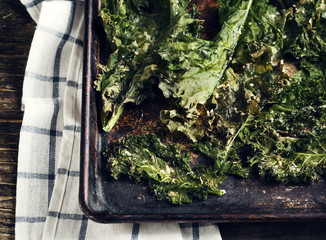 Wall Mural - Crispy cheese and chili kale chips on baking tray. Toned image