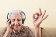 © berna_namoglu - senior old woman listening music with headphone