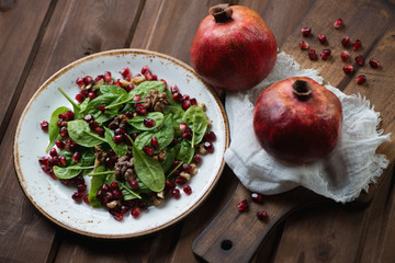 Wall Mural - Salad with spinach leaves, pomegranate seeds and walnuts