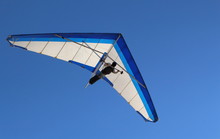 Hang Glider Flying In The Sky On A Bright Blue Day