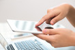 © jannoon028 - Woman hand touch white tablet with blank empty screen