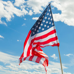 Wall Mural - USA flag with clouds on background - close up outdoors shot