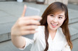 © zhu difeng - asian beautiful young woman using mobile phone to take selfie ou