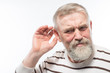 © kostyha - an old man with a beard is hard of hearing, health problems