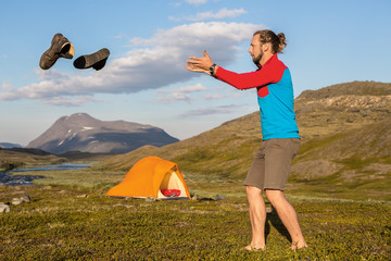 Wall Mural - flying hiking boots over a tent