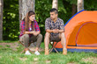 © bokan - Young woman and man sitting in front of the tent talking