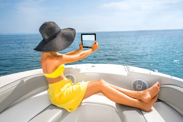 Poster - Woman relaxing with digital tablet on the yacht