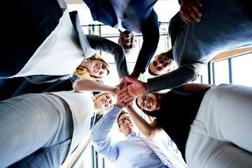 group of executives looking down hands together