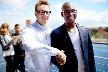 Wall Mural - White colleague and black colleague shaking hands