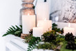 © RooM The Agency - Close-up of Lit Candles on a fireplace mantelpiece decorated with assorted fresh foliage