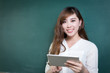 © zhu difeng - asian beautiful woman holding tablet in front of blackboard
