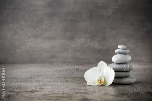 Dekoracja na wymiar  biala-orchidea-i-kamienie-spa-na-szarym-tle