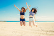 © asife - Funny girl frinds jumping on the beach