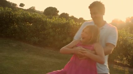 father and daughter twirling in sunset