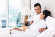 © Kzenon - Asian couple lounging in bed at morning