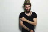 Fototapeta  - Smiling Hipster boy.handsome man in hat.Brutal bearded man with tattoo