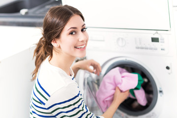 Woman loading washing machine
