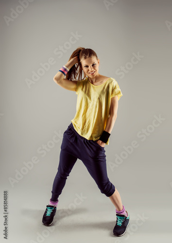 Young woman hip hop dancer in sportswear posing in studio Plakát