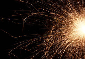 Fire spray from sparklers on black background, macro