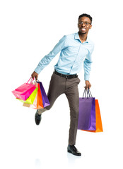 Happy african american man holding shopping bags on white backgr