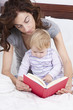 © Q - baby and mom reading in bed