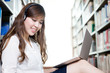© zhu difeng - Asian beautiful female student studying in library with laptop
