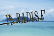 Paradise sign with a sea and islands on background.