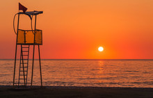Lifeguard Rescue Tower On Sea Beach At Sunset