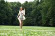 © Andrey_Arkusha - Young beautiful girl in the white shirt is running on the green
