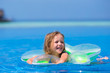Little happy adorable girl in outdoor swimming pool