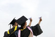 © hxdyl - Beautiful female graduate wearing graduation gown, throwing airplane