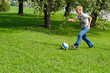 © nvelichko - Young boy playing football outdoors