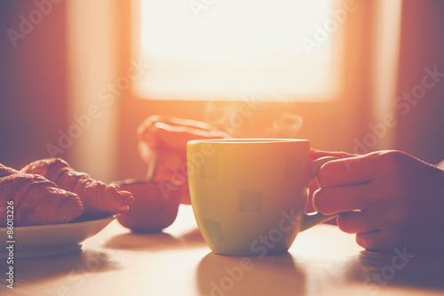 Fotografie, Obraz fresh breakfast with hot coffee and croissant in morning sunligh