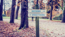 Signboard With Two Signs Saying - Nothing- Everything - Pointing