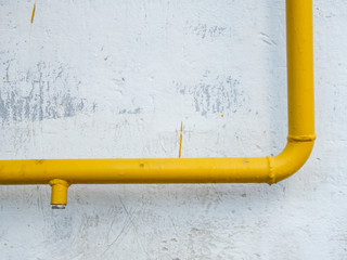 Yellow gas pipe in front of residential building wall