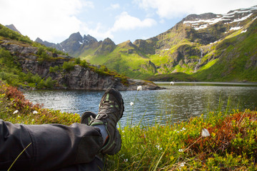 hiker resting near mountain lake
