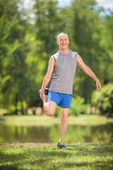 Sticker - Joyful senior stretching his legs in a park