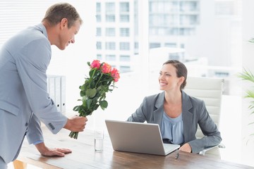 Wall Mural - Businessman offering flowers to his colleague