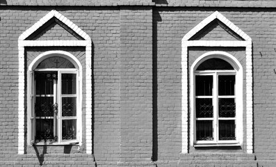 two windows with barred on the outside wall