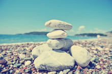 Stack Of White Stones Balancing On The Pebbly Beach, On A Sunny Day. Image Filtered In Faded, Washed Out, Retro Style; Summer Vintage Concept.