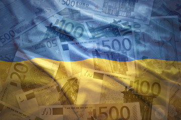 Wall Mural - colorful waving ukrainian flag on a euro money background