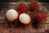 Red rambutan Nephelium lappaceum on broun board. Fruit tropical tree of the family Sapindaceae , native to South - East Asia , cultivated in many countries in the region