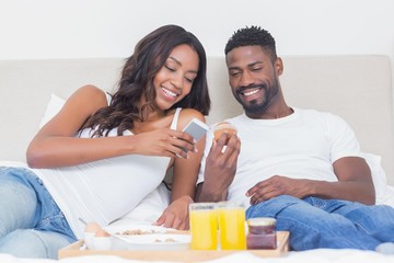 Wall Mural - Relaxed couple having breakfast in bed together