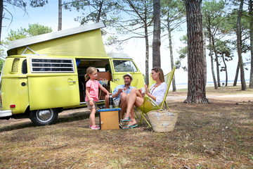 Wall Mural - happy family relaxing by camper van in summer