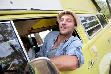 Wall Mural - Trendy guy riding a vintage camper van