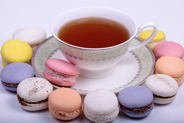 Cup of tea with colorful french macaron